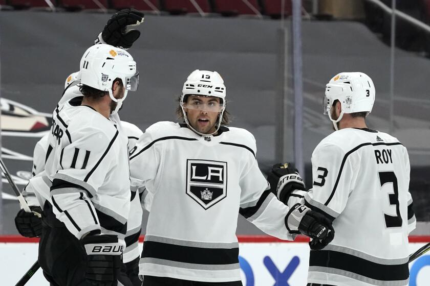 The Kings' Alex Iafallo, center, celebrates a goal against Arizona with teammates Matt Roy, right, and Anze Kopitar.