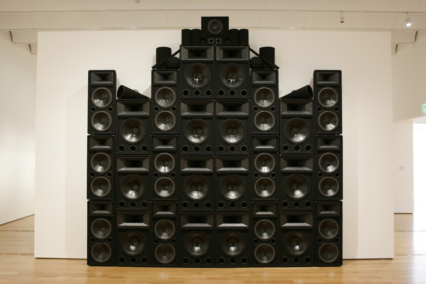 A stack of speakers form the outline of a Gothic church building