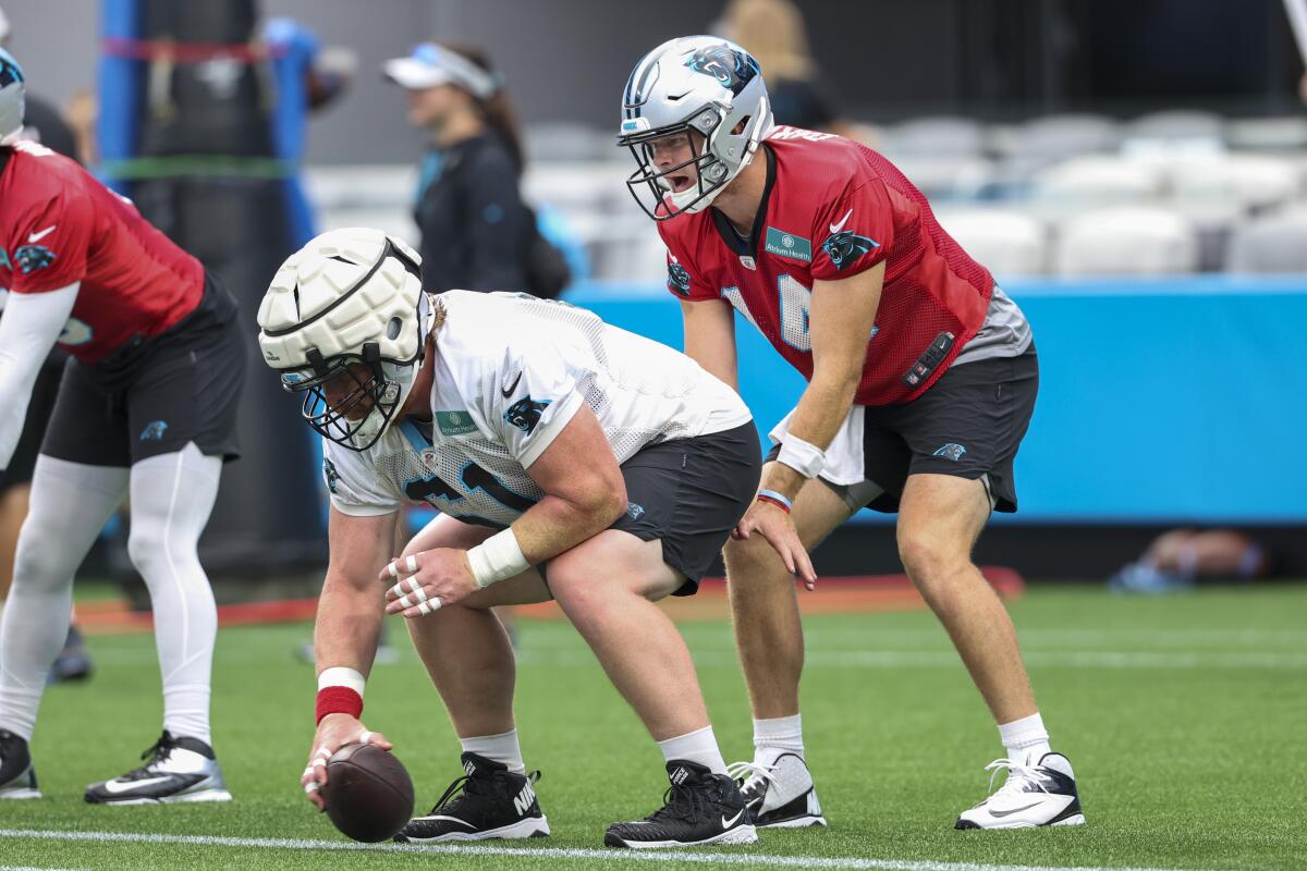 Carolina Panthers quarterback Sam Darnold, right, takes the snap from center Matt Paradis during a Fan Fest practice at the NFL football team's training camp in Charlotte, N.C., Friday, Aug. 6, 2021. (AP Photo/Nell Redmond)