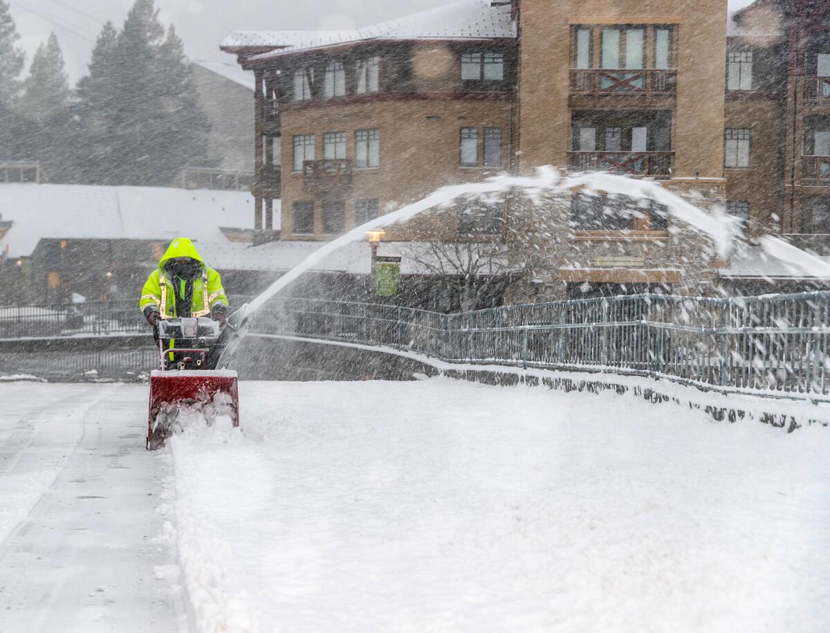 A worker clears snow from the Palisades Tahoe ski area near Lake Tahoe.
