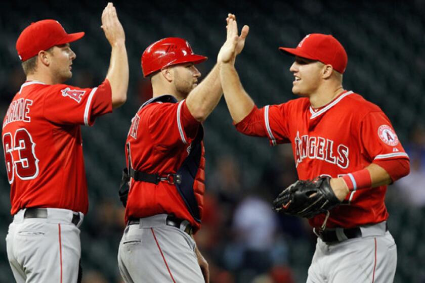 Angels center fielder Mike Trout, right, congratulates teammates Chris Iannetta, center, and Nick Maronde after the Angels' 11-1 win over the Houston Astros on Friday.