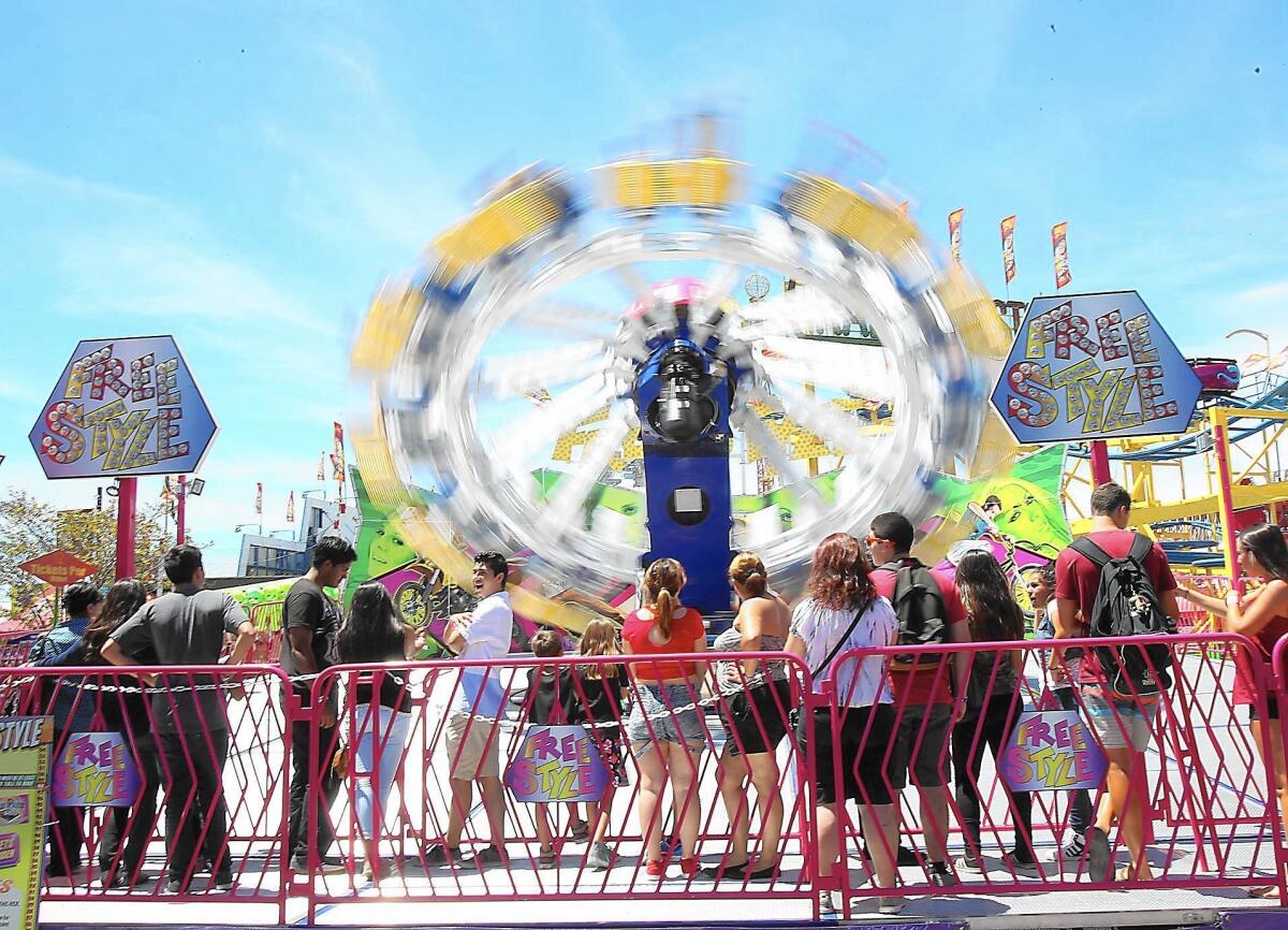 A line forms in front of the popular Free Style spin ride at the OC Fair.