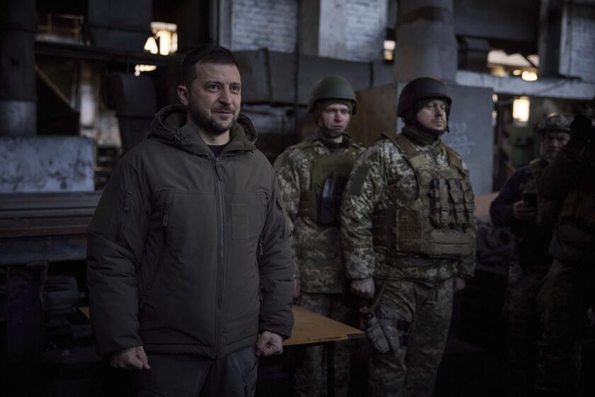 In this photo provided by the Ukrainian Presidential Press Office, Ukrainian President Volodymyr Zelenskyy, left, speaks to soldiers at the site of the heaviest battles with the Russian invaders in Bakhmut, Ukraine, Tuesday, Dec. 20, 2022. (Ukrainian Presidential Press Office via AP)