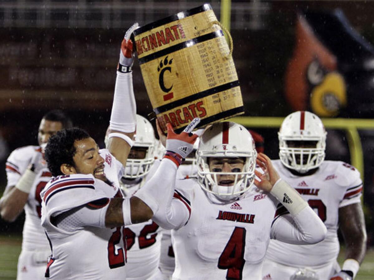 Louisville players -- led by Jordon Paschal (22) and Will Stein (4) -- celebrate with the "Keg of Nails" trophy after beating Cincinnati in overtime this year.