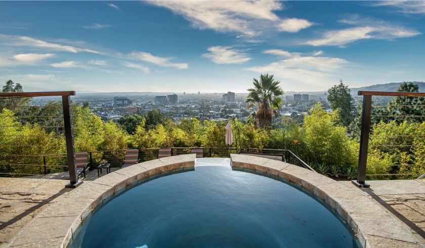 The hillside home includes three levels of decks, balconies and patios, as well as a swimming pool and spa.