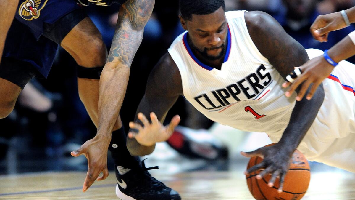Clippers forward Lance Stephenson grabs control of a loose ball in front of Pelicans forward Alonzo Gee in the first half of a game Friday, Nov. 27.