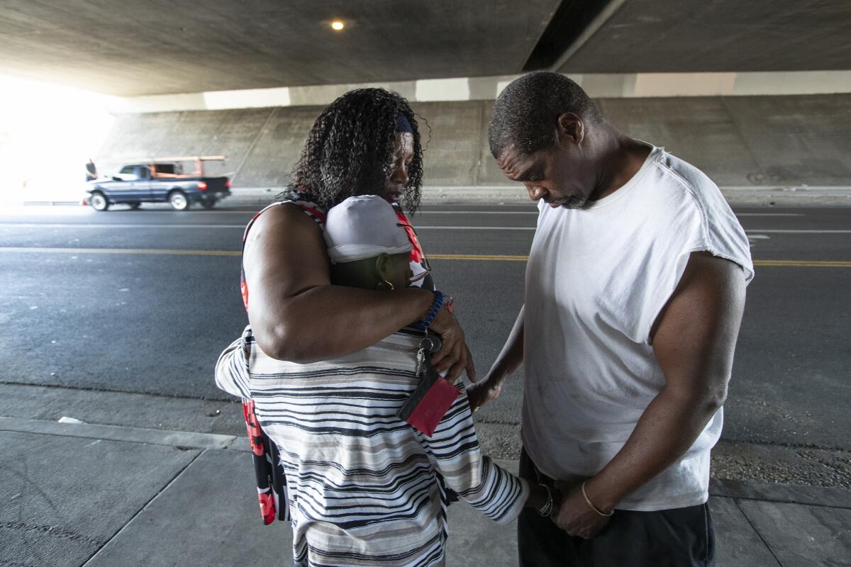 Sandra Wilson, top left, regularly travels from Mojave to pray with the people who live in the Pacoima homeless encampment.