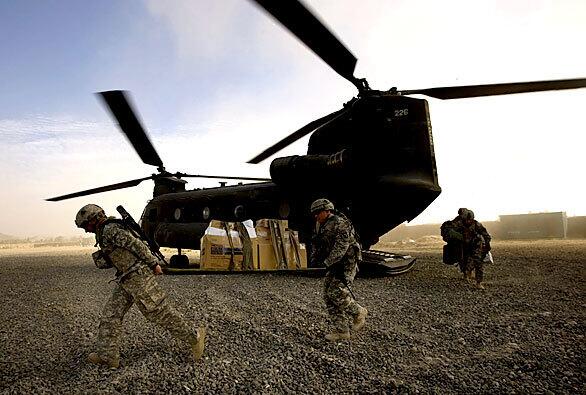 U.S. Army soldiers from maneuver platoon HHB 4-320FA carry fresh supplies off a UH-47 helicopter at their outpost in Afghanistan's Khowst province on Monday. Khowst province is located across the border from the lawless Waziristan region in Pakistan, from which it is believed foreign fighters flood into Afghanistan to attack coalition forces.