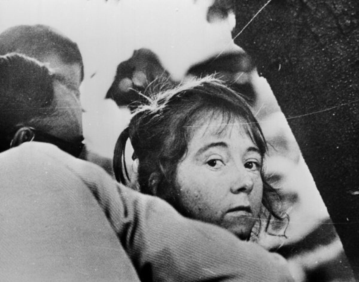 Lynette "Squeaky" Fromme is led away after her failed 1975 assassination attempt on President Ford.