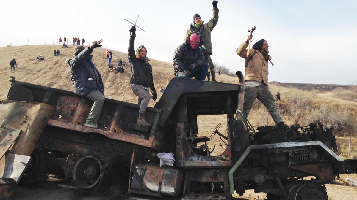 Protesters against the Dakota Access oil pipeline stand on a burned-out truck near Cannon Ball, N.D., on Nov. 21.