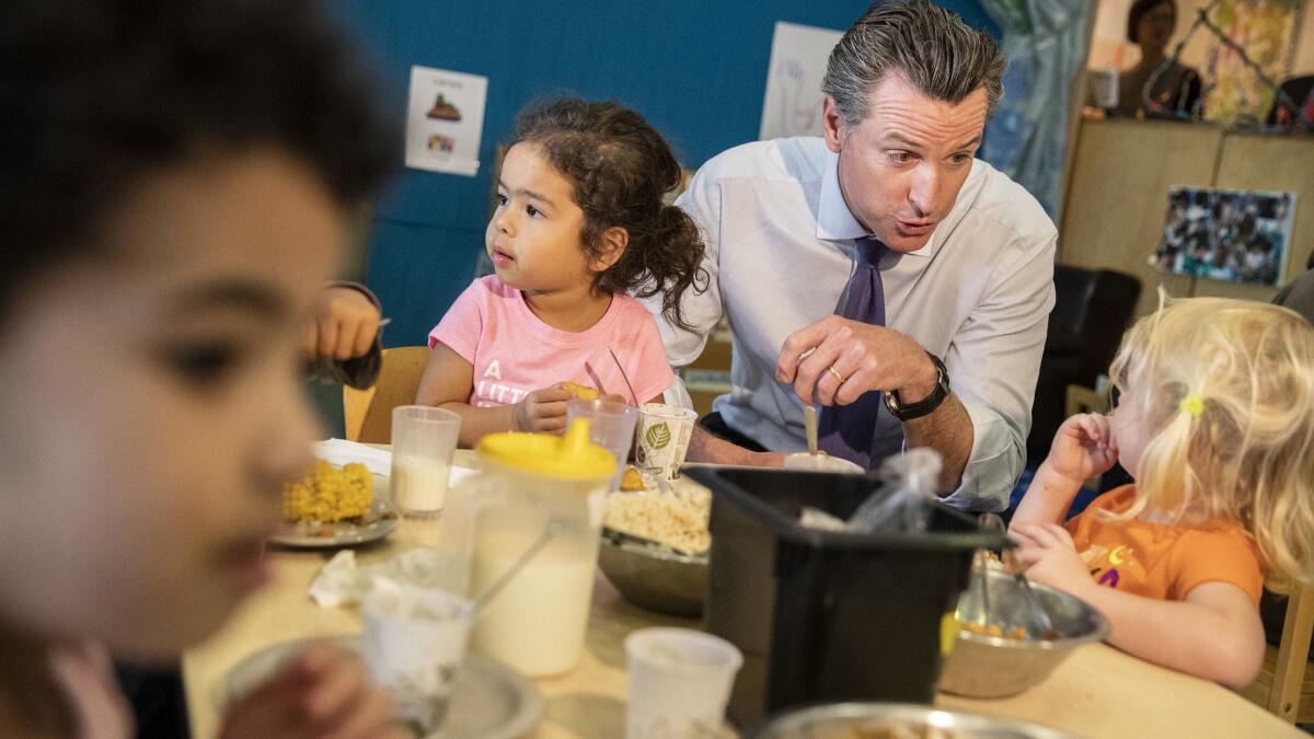 Lt. Gov. Gavin Newsom, Cox's Democratic rival, visits with children at UCLA's University Village Center on Wednesday.