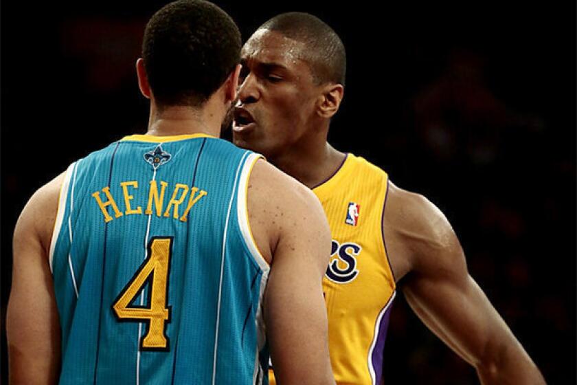 Lakers forward Metta World Peace jaws with New Orleans guard Xavier Henry.