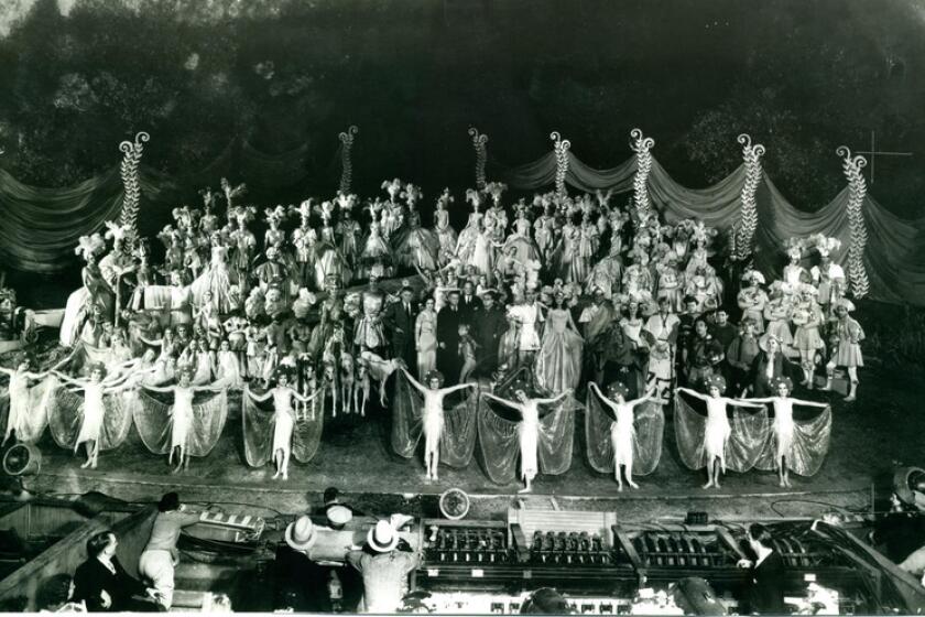 A cast poses onstage.