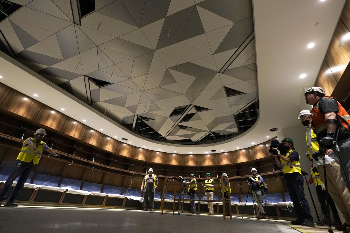 Visitors view the home hockey locker room at Climate Pledge Arena during a media tour of the facility, Monday, July 12, 2021, in Seattle. The arena will be the home of the NHL hockey team Seattle Kraken and the WNBA Seattle Storm basketball team as well as hosting concerts and other performing arts events. (AP Photo/Ted S. Warren)