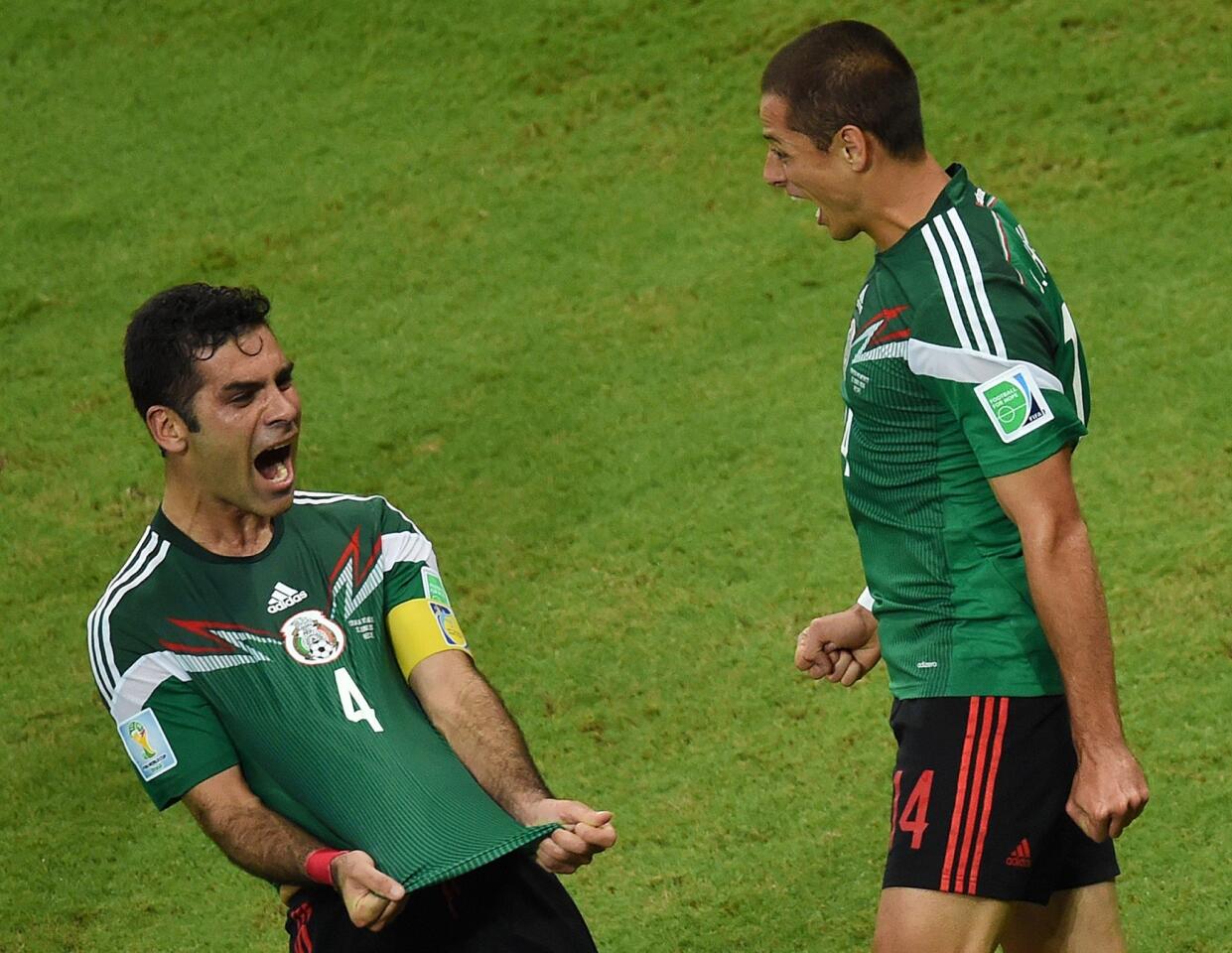 Mexico's defender Rafael Marquez celebrates after scoring his team's first goal as Javier Hernandez reacts.