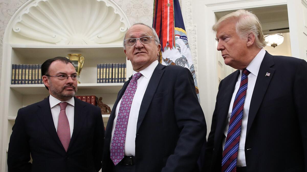 Mexican Foreign Secretary Luis Videgaray, left, and Jesus Seade, representative in the trade talks of Mexican President-elect Andres Manuel Lopez Obrador, gather with President Trump in the Oval Office for a call Monday between Trump and Mexican President Enrique Peña Nieto.