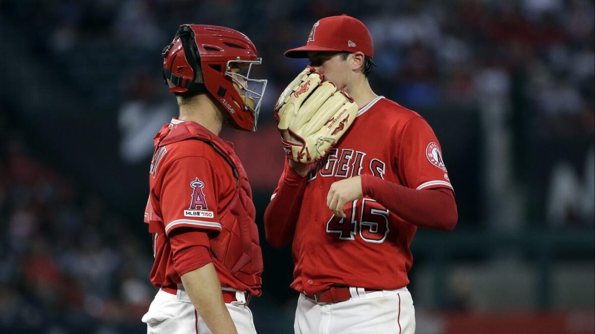 Angels catcher Dustin Garneau confers with Tyler Skaggs during the pitcher's final game against the Oakland Athletics on June 29.