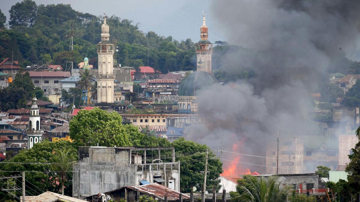 A fire rages following Philippine air force strikes on militants in Marawi on May 27.
