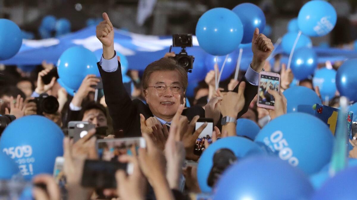 South Korean presidential candidate Moon Jae-in of the Democratic Party gives his supporters a thumbs-up sign upon his arrival at an election campaign in Seoul on Monday.