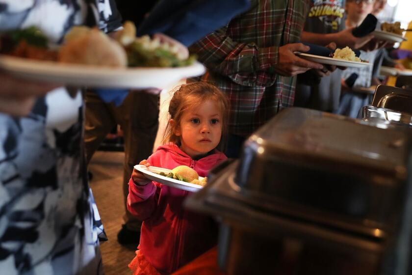 CHICO, CA - NOVEMBER 22: A young Camp Fire evacuee waits in line to receive a free Thanksgiving meal at Sierra Nevada Brewery on November 22, 2018 in Chico, California. Fueled by high winds and low humidity the Camp Fire ripped through the town of Paradise charring over 150,000 acres, killed at least 83 people and has destroyed over 18,000 homes and businesses. The fire is currently at 85 percent containment and hundreds of people still remain missing. (Photo by Justin Sullivan/Getty Images) ** OUTS - ELSENT, FPG, CM - OUTS * NM, PH, VA if sourced by CT, LA or MoD **