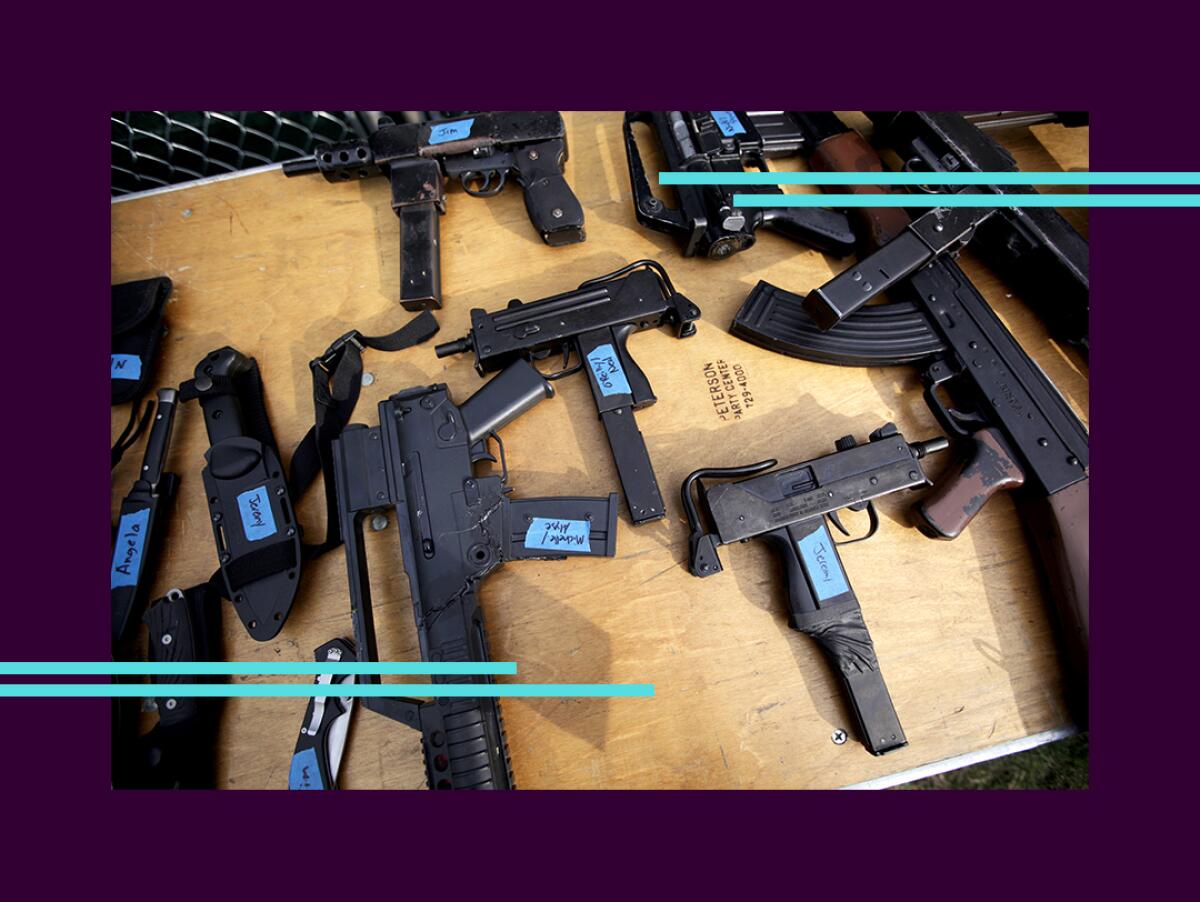 Several guns with labels are laid out on a table.