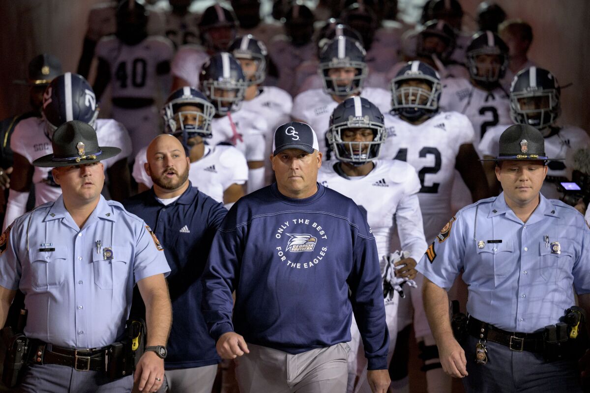 L'entraîneur de Georgia Southern, Clay Helton, mène ses joueurs sur le terrain avant un match contre Louisiana Lafayette le 10 novembre.