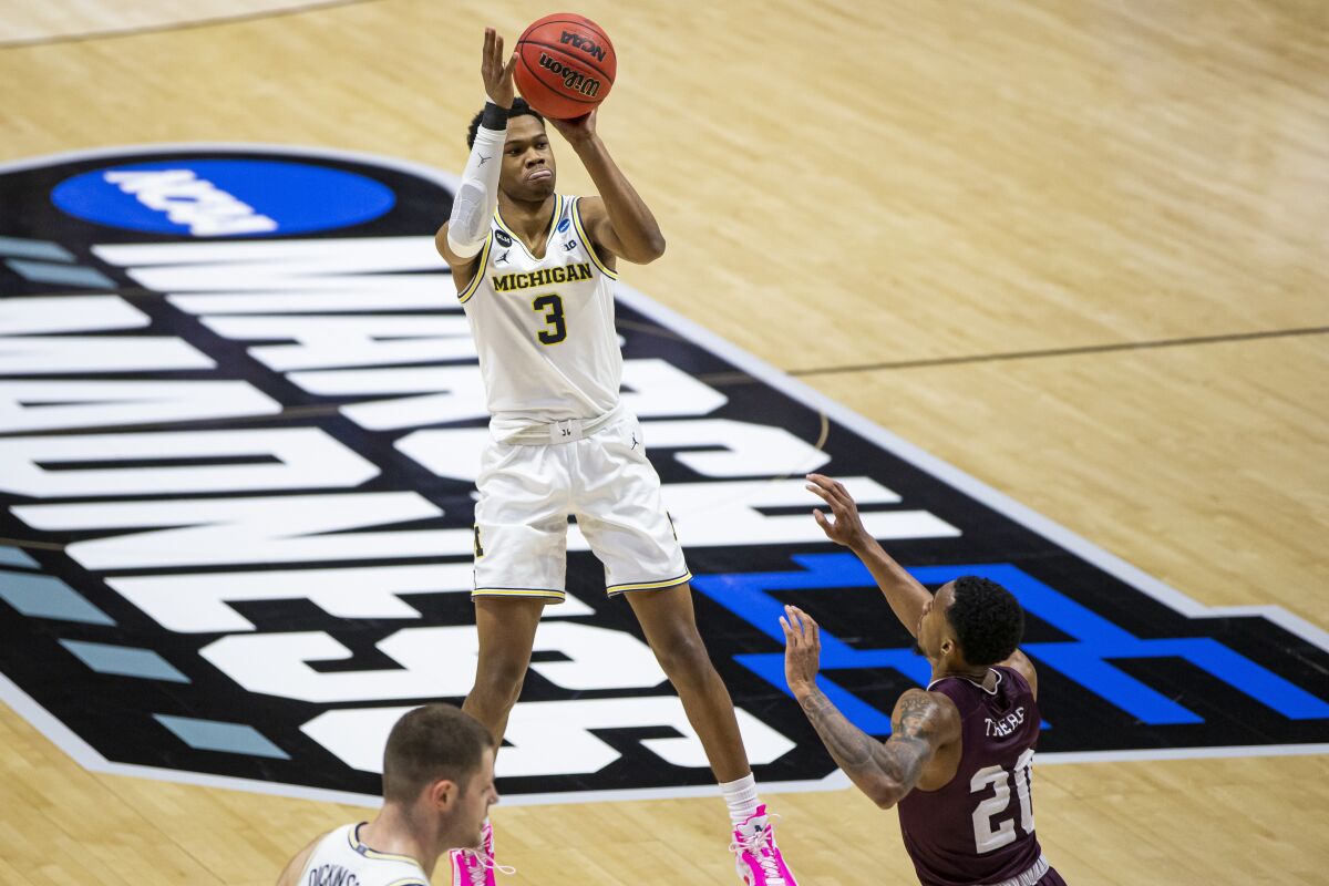Michigan's Zeb Jackson shoots a three-pointer over Texas Southern's Michael Weathers.
