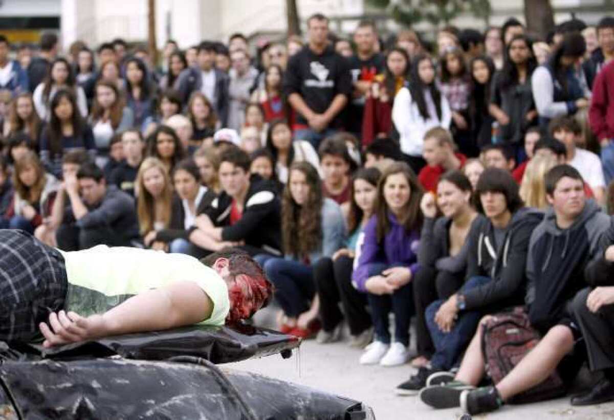 La Canada High School student Connor Boyd acts dead during the anti-drunk driving program Every 15 Minutes, staged in front of the school in La Canada Flintridge on Thursday. Actual first responders like the local L.A. County Fire Department, L.A. County Sheriff, L.A. County Coroner, and California Highway Patrol officers responded to the scene.