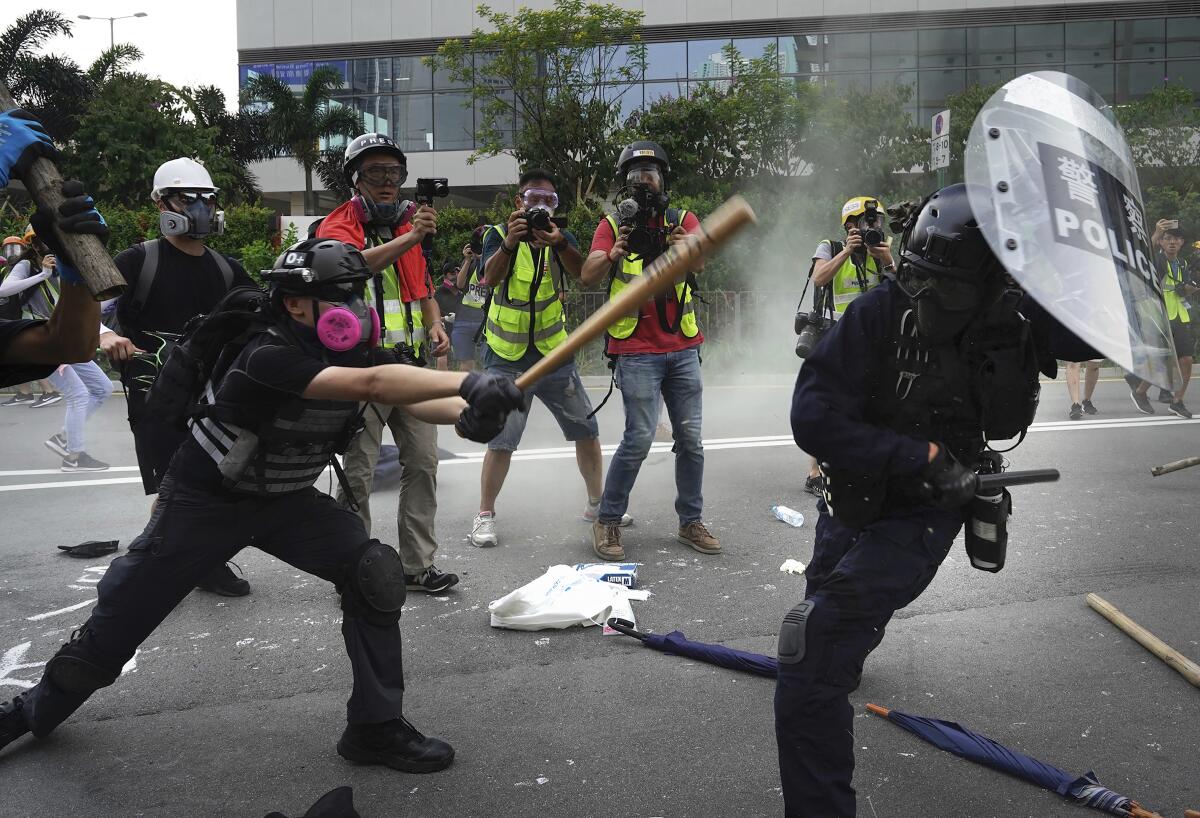 Police and demonstrators clash during a protest in Hong Kong, Saturday, Aug. 24, 2019. Chinese police said Saturday they released an employee at the British Consulate in Hong Kong as the city's pro-democracy protesters took to the streets again, this time to call for the removal of "smart lampposts" that raised fears of stepped-up surveillance. (AP Photo/Vincent Yu)