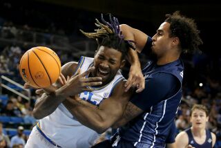 LOS ANGELES, CALIF. - DEC. 21, 2022. UCLA Bruins forward Kenneth Nwuba fights for control of the ball.
