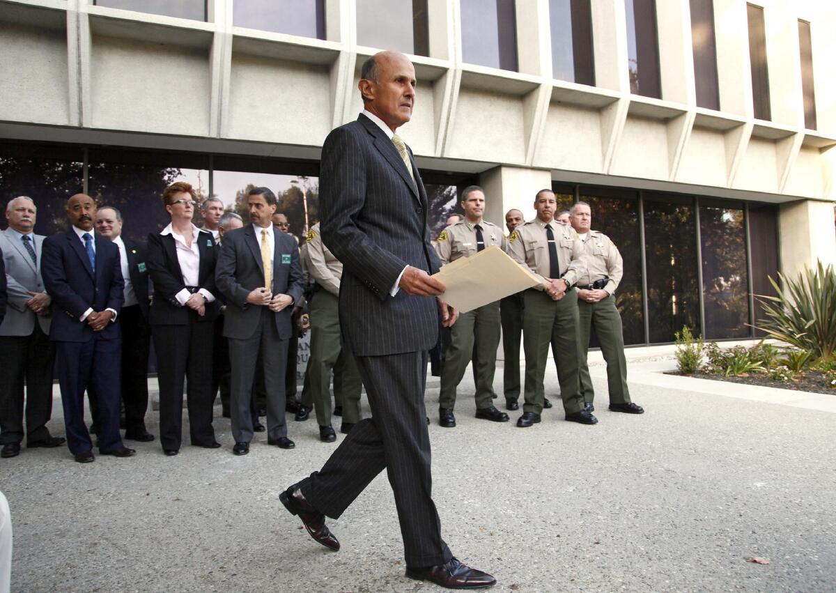 Los Angeles County Sheriff Lee Baca arrives at a news conference after the FBI released results of a federal probe. On Dec. 17, he is due to report on the previous week's scandal: the hiring of dozens of deputies with personnel records that showed lying, cheating, excessive force and irresponsible use of firearms.