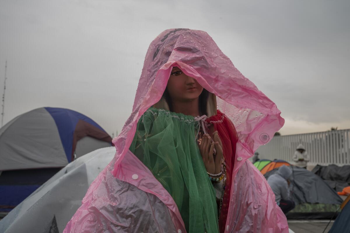 Фигура Девы Гваделупской, накрытая полиэтиленовым пакетом, чтобы защитить фигуру от дождя.