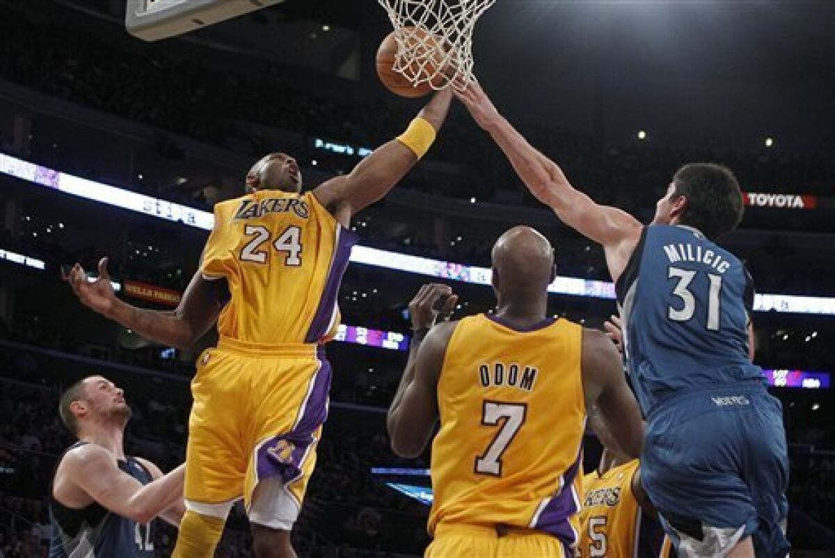 Los Angeles Lakers guard Kobe Bryant, left, gets a rebound against Minnesota Timberwolves center Darko Milicic during the first half of an NBA basketball game in Los Angeles, Tuesday, Nov. 9, 2010. (AP Photo/Jae C. Hong)