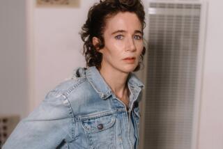 Miranda July, with short curly brown hair and a distressed denim jacket, looks into the camera.
