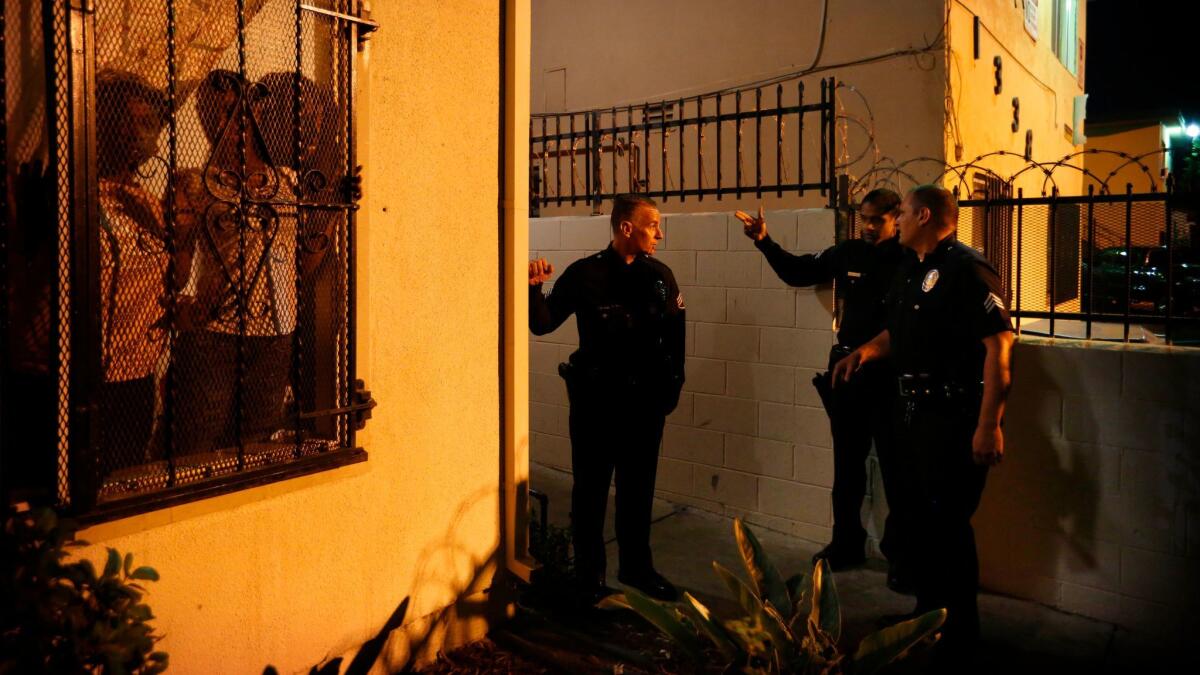 Sgt. Jeritt Severns, left, speaks with other LAPD officers about a shooting call in South L.A.