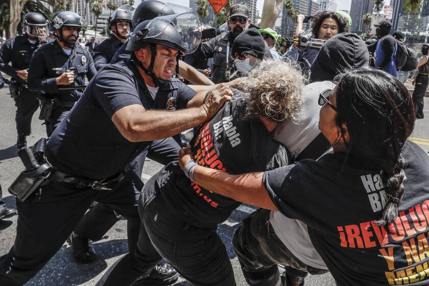 Los Angeles, CA, Tuesday, August 22, 2023 - LAPD officers scuffle with lgbtq protesters as they try to keep them away from a Parents Rights group demonstration near the downtown LAUSD offices. (Robert Gauthier/Los Angeles Times)