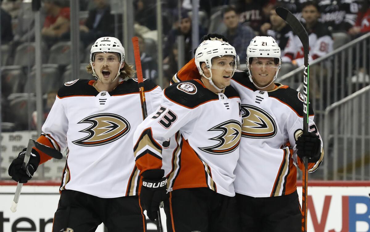 Ducks right wing Jakob Silfverberg celebrates with Simon Benoit and Isac Lundestrom after scoring a goal.