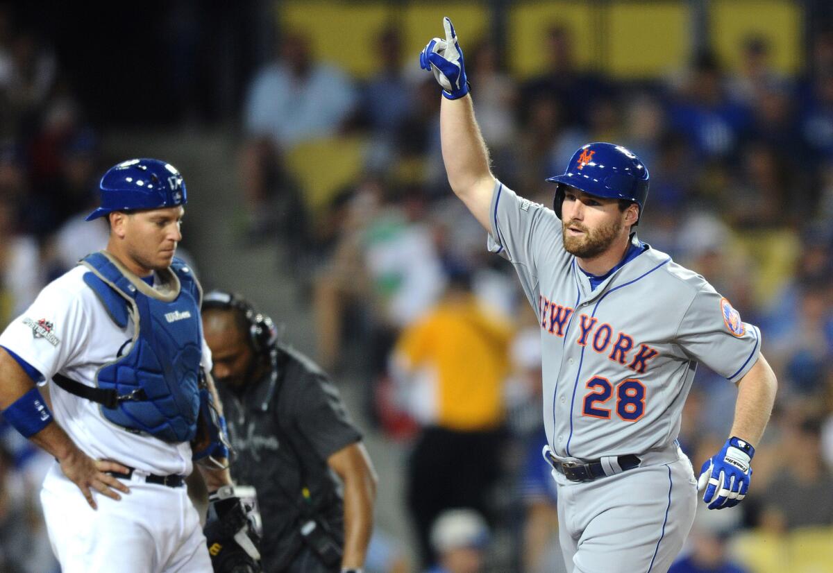 Mets infielder Daniel Murphy raises his arm in front of Dodgers catcher A.J. Ellis after hitting a solo home run against Clayton Kershaw in the fourth inning of Game 1 of the NLDS.