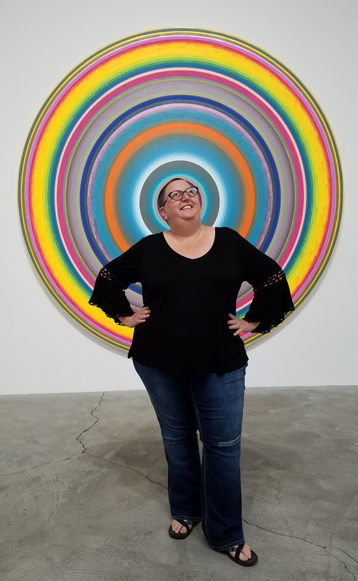 Artist Kristine Schomaker, photographed in front of artwork by Gary Lang