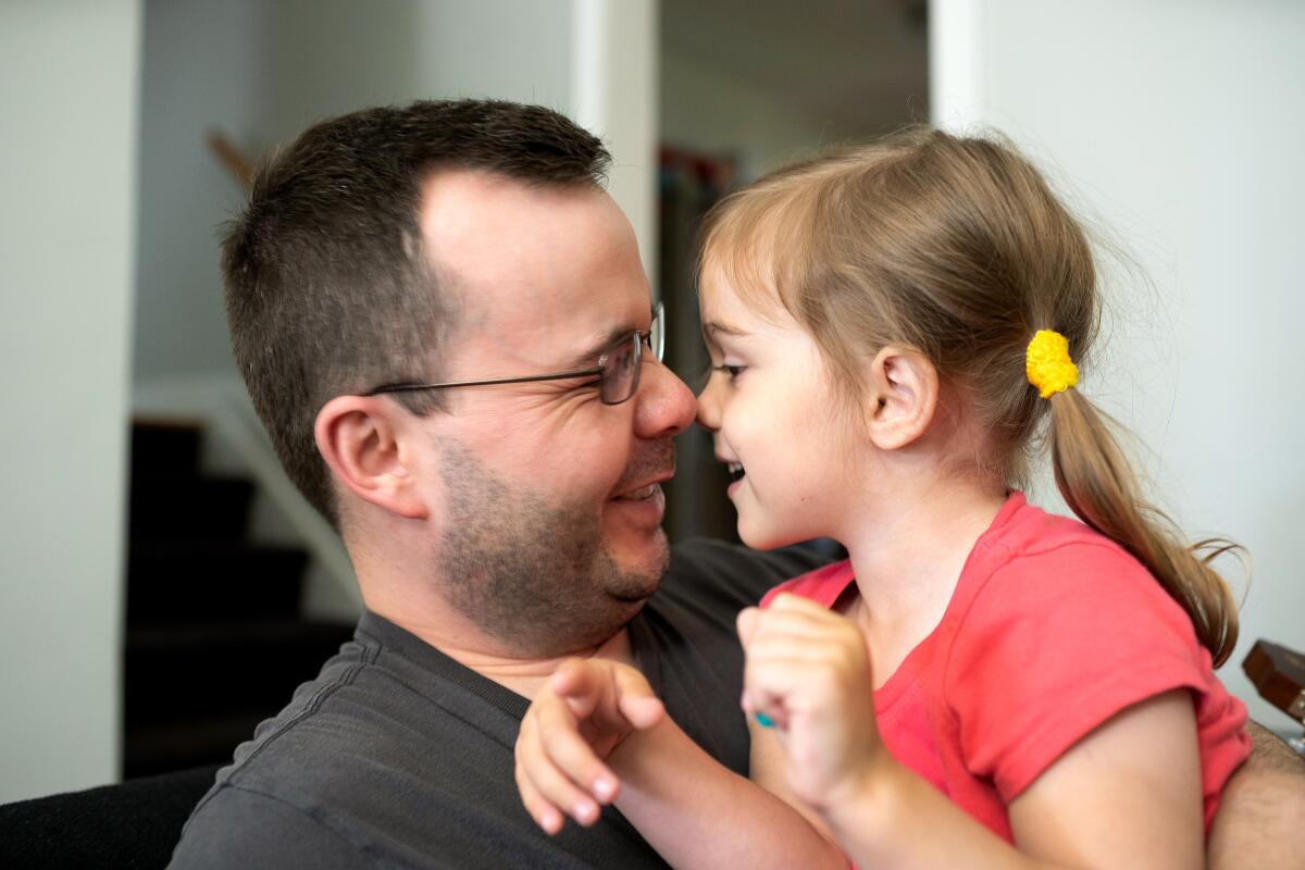 Shawn Stevens de Trenton, Michigan, juega en casa con su hija de 3 años Selena, que tiene autismo. Él y su esposa tienen que trabajar largas horas para cubrir los copagos de su seguro médico.