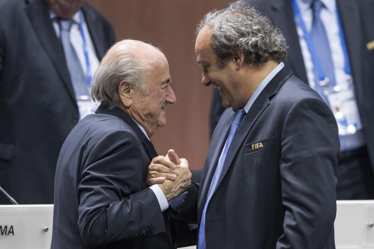 Sepp Blatter (izquierda), después de ser reelegido como presidente de la FIFA, estrecha la mano del líder de la UEFA, Michel Platini en el Hallenstadion en Zurich, Suiza.