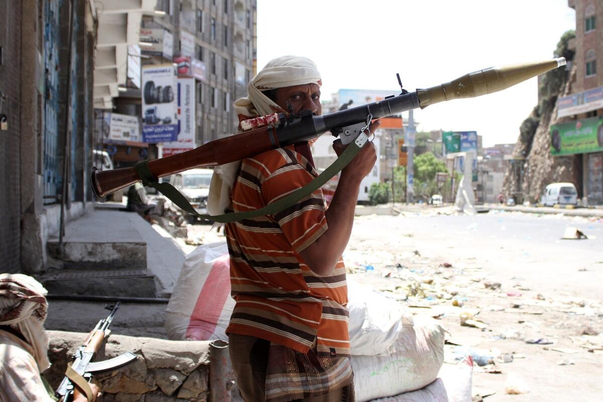 Yemeni tribal gunmen loyal to President Abdu Rabu Mansour Hadi monitor a street during clashes with Shiite Muslim Houthi rebels on Thursday in the city of Taizz.