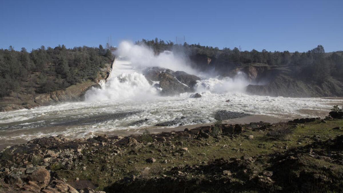 Water flows down the damaged main spillway of the Oroville Dam.