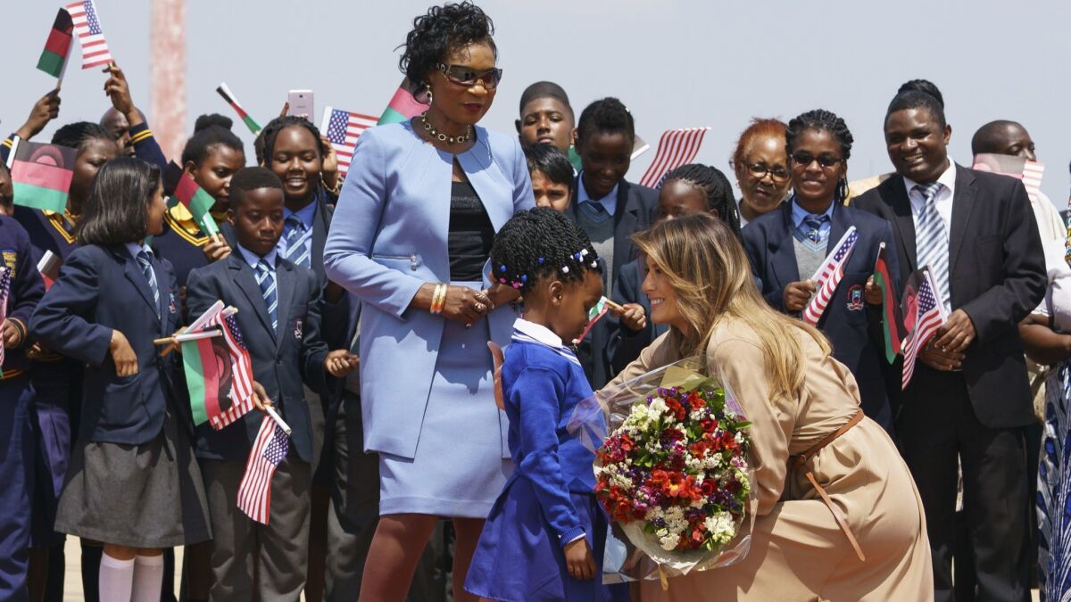 First Lady Melania Trump is greeted by Malawian First Lady Gertrude Mutharika and a flower girl upon her arrival.
