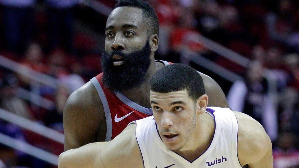 Houston Rockets guard James Harden (13) and Lakers guard Lonzo Ball (2) hold each other in the second half on Wednesday.