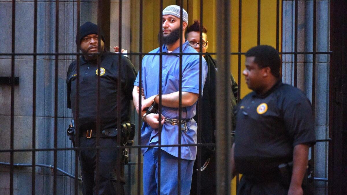 Officials escort Adnan Syed, the focus of the first "Serial" podcast, from a Baltimore courthouse in 2016. An appeals court has upheld a ruling granting Syed a new trial.