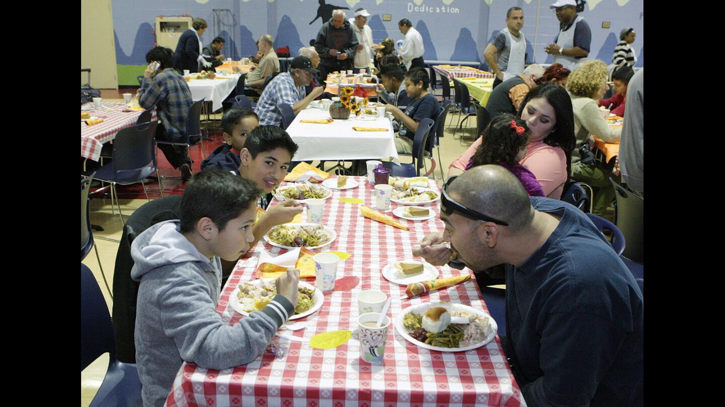 The Martinez family enjoys a Thanksgiving meal at the Salvation Army Glendale Corps and Community Center Thanksgiving dinner in Glendale on Thursday, Nov. 26, 2015.