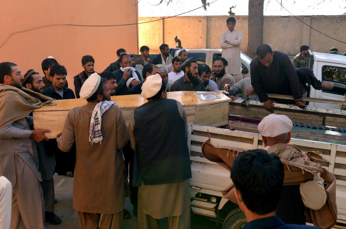 Afghan men carry the coffin of a victim after a suicide attack in Kunar province, east of Kabul.