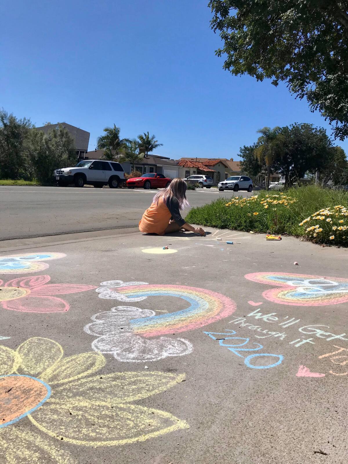 Avery Guyader, 11, beautifies the driveway of her family's Pacific Beach home during a Chalk the Walk event last weekend.