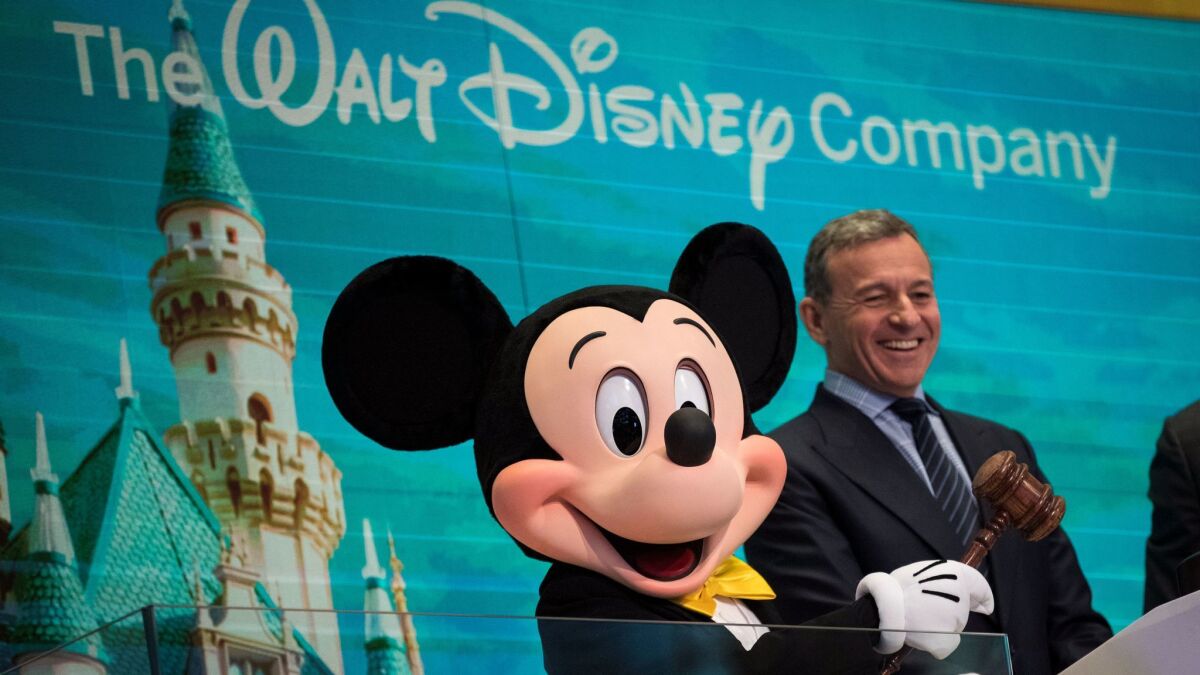 Mickey Mouse and Bob Iger, Walt Disney Co.'s chairman and chief executive, ring the opening bell at the New York Stock Exchange on Nov. 27 to mark Disney's 60th anniversary as a listed company on the NYSE.